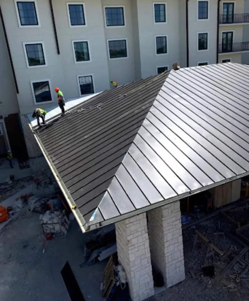 Crew installing standing seam metal roof panels on a commercial project in White Rock
